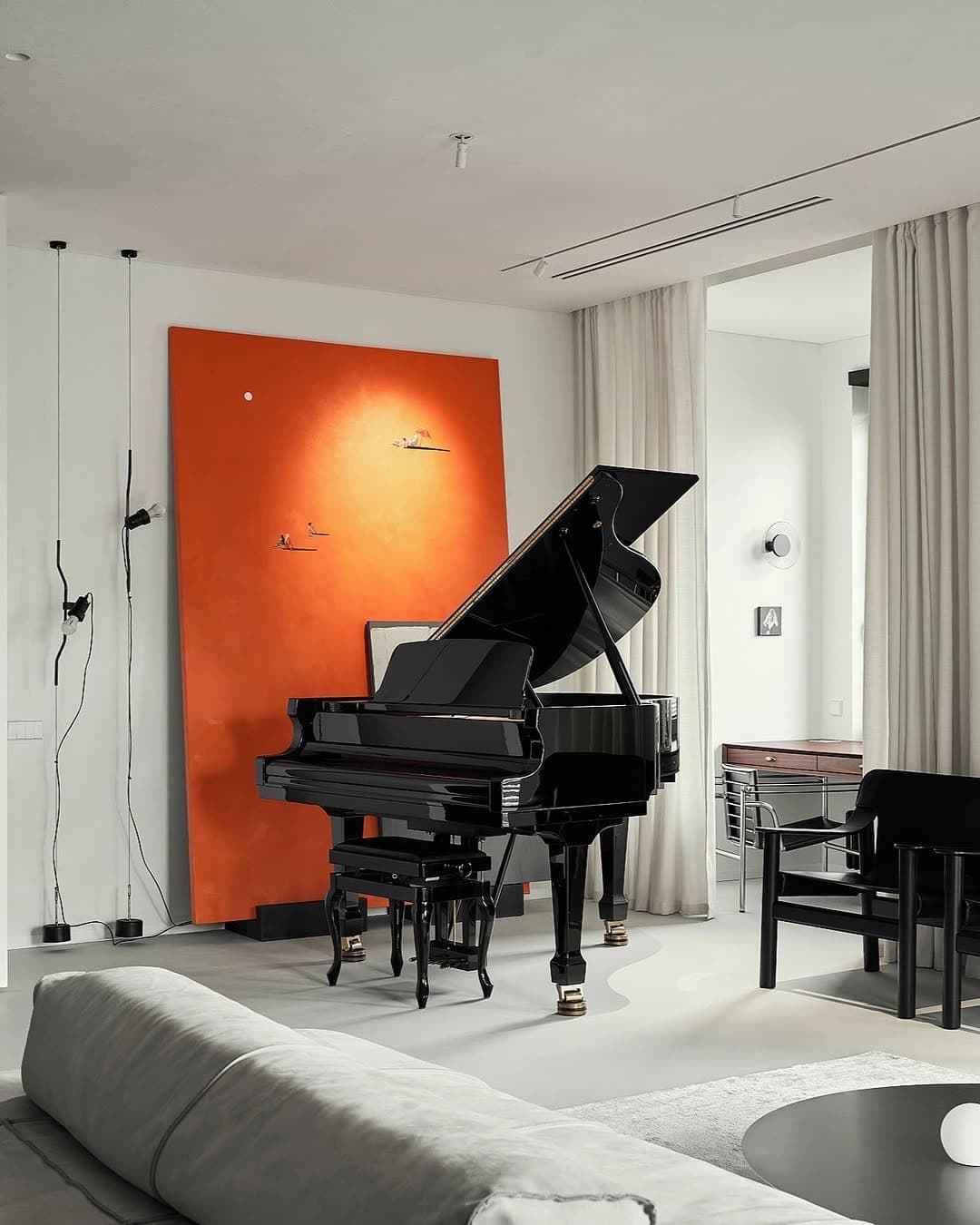 Piano de cauda junto à janela e a uma pintura vermelha.