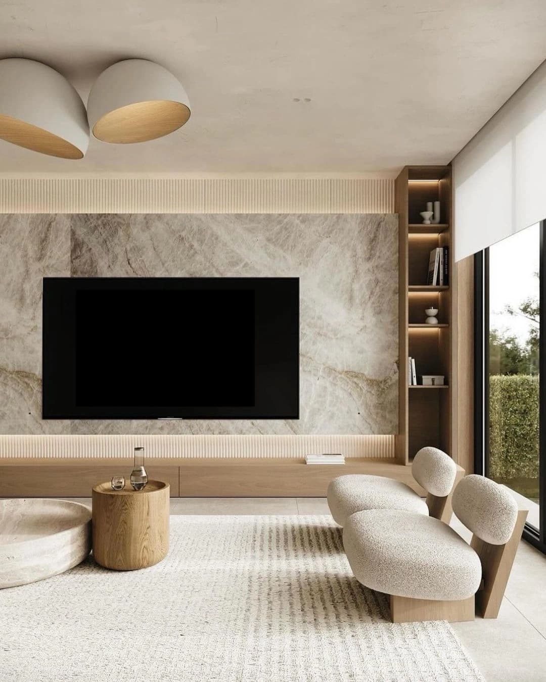 Painel de televisão revestido de pedra, estante e poltrona clara.