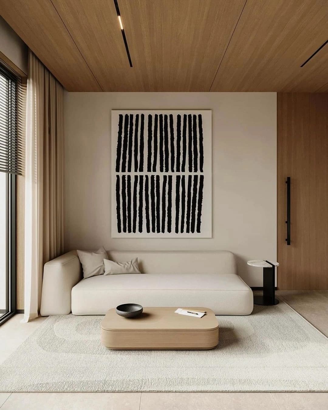 Canto de estar com sofá, mesa de madeira e obra de arte gráfica.