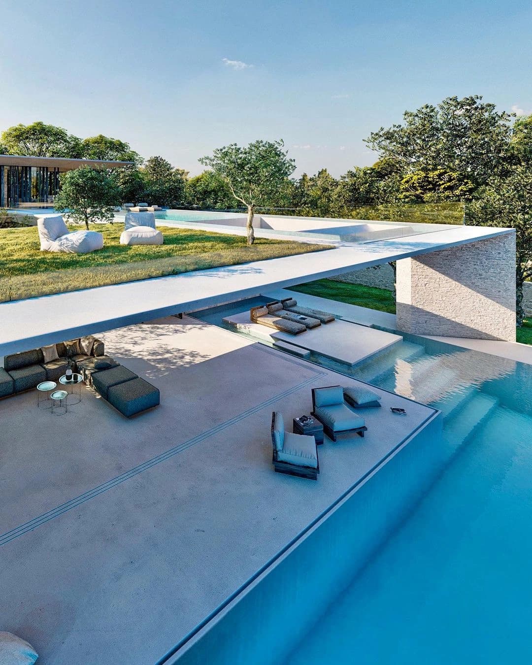 Piscina com espreguiçadeiras e jardim ao redor.